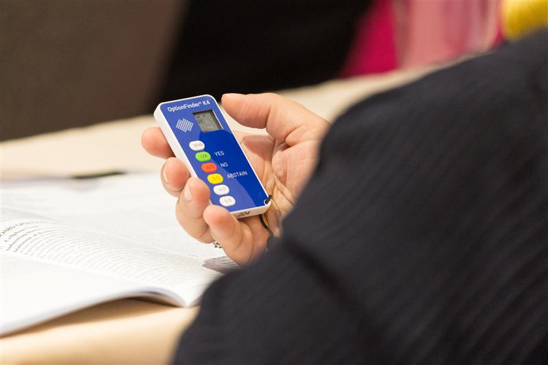 Person holding a blue voter clicker device
